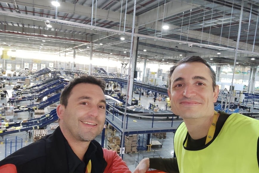 Ignacio Martinez (der) junto a uno de sus compañeros de trabajo en la planta de distribución de Mercado Libre.