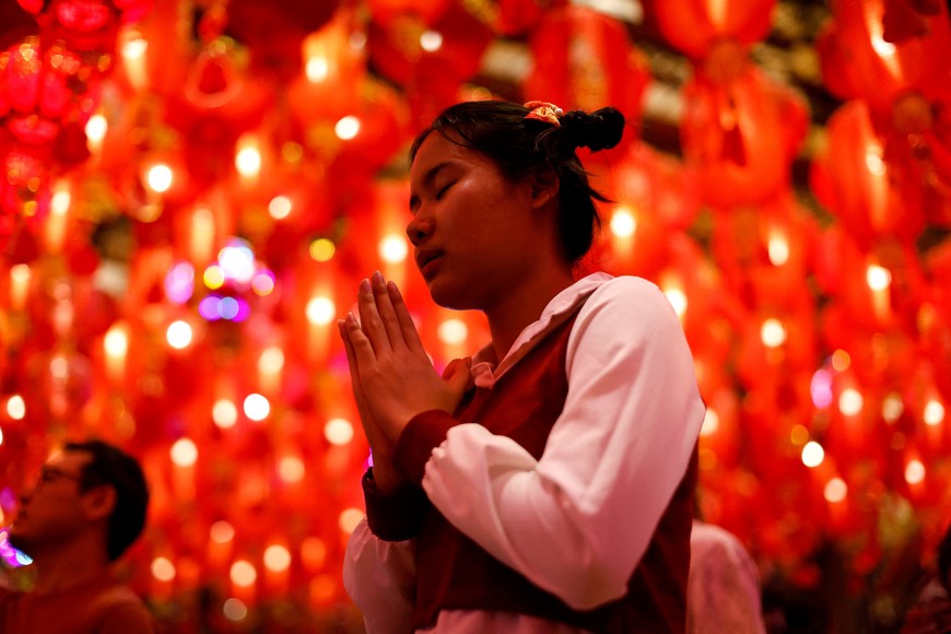 A girl prays at Wat Mangkon temple during the Lunar New Year's eve in Chinatown Bangkok, Thailand February 9, 2024. REUTERS/Jorge Silva