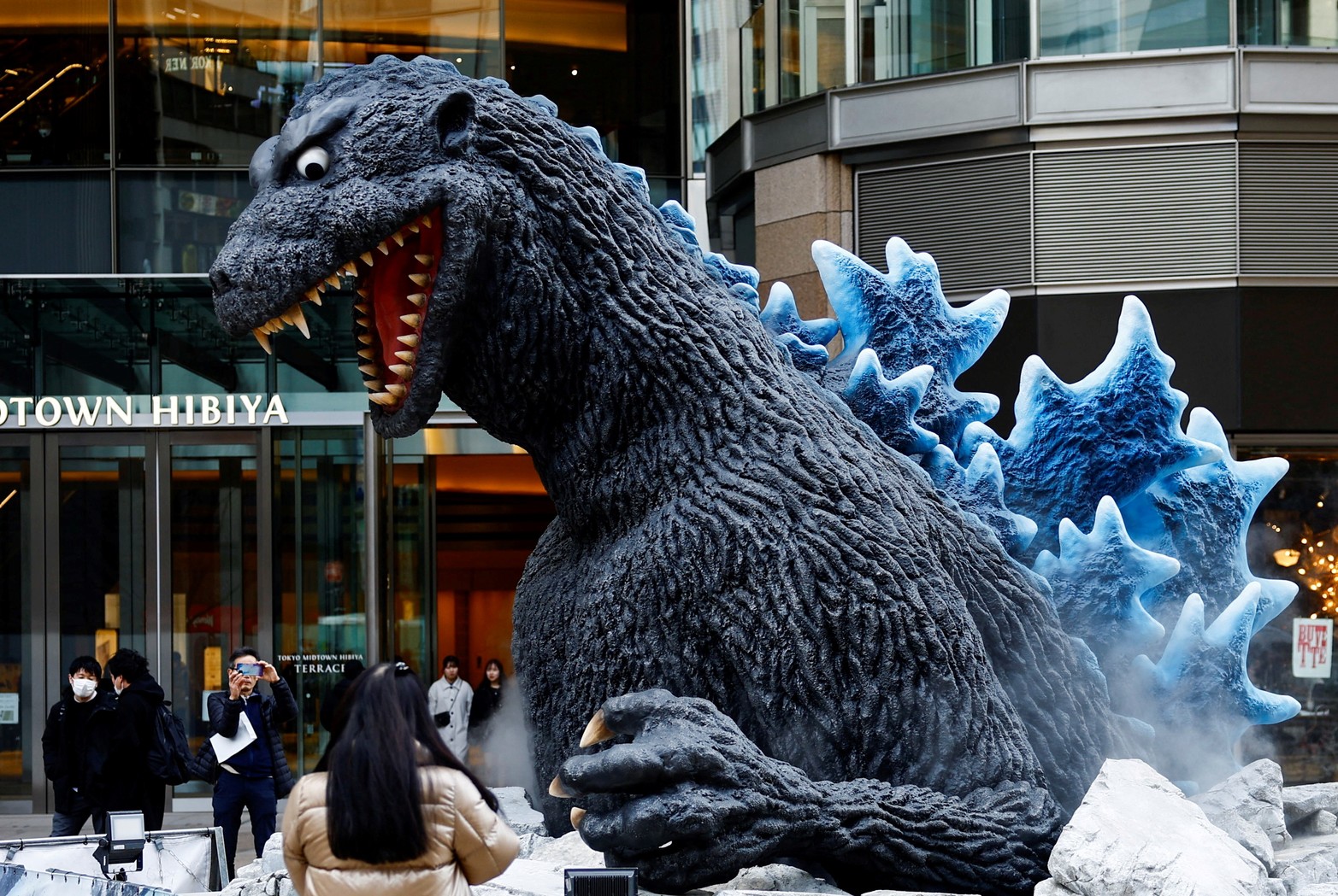 La gente toma fotografías de una estatua de Godzilla que se instala para promocionar la película 'Godzilla Minus One' después de que la película ganó el Oscar a los mejores efectos visuales durante la entrega de los Oscar en la 96a edición de los Premios de la Academia en Hollywood, en Tokio, Japón.
