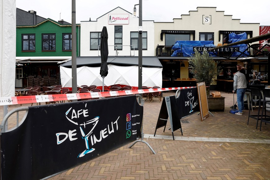 People clean the surroundings of the Cafe Petticoat, where several people were held hostage in Ede, Netherlands March 30, 2024.  REUTERS/Piroschka Van De Wouw