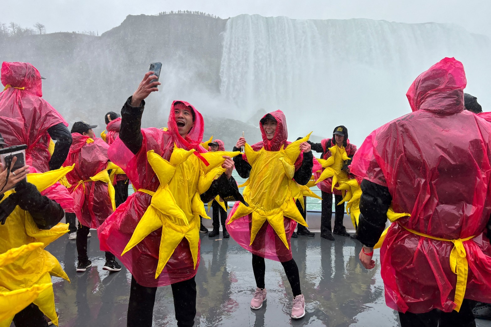 Algunas de las 309 personas se reunieron para romper el récord mundial Guinness del grupo más grande de personas vestidas como el sol posan en un barco turístico, antes del eclipse solar total en las Cataratas del Niágara, Ontario, Canadá,