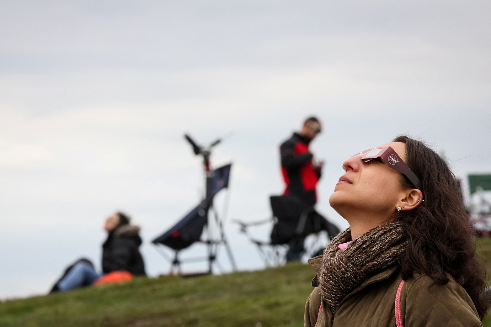 Una mujer observa un eclipse solar total, donde la luna borrará el sol, en las Cataratas del Niágara, Nueva York.