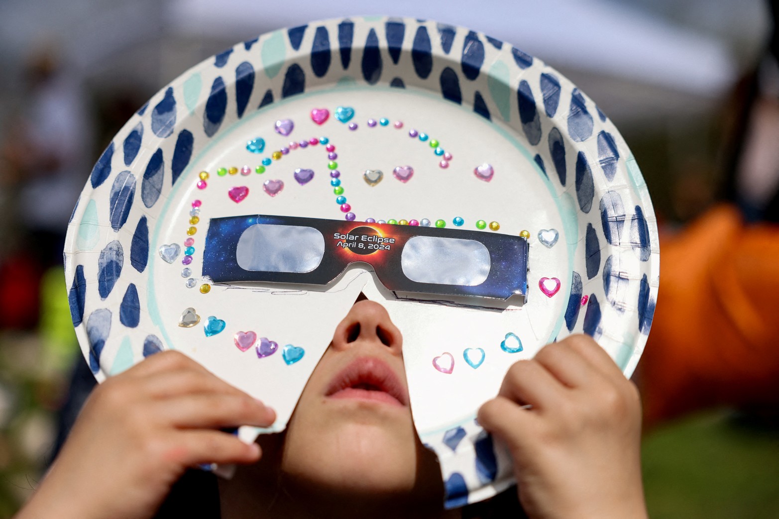 Sophia Moccia, de 4 años, de Queens ve un eclipse solar parcial con una máscara casera, en el New York Hall of Science en el distrito de Queens, Nueva York.