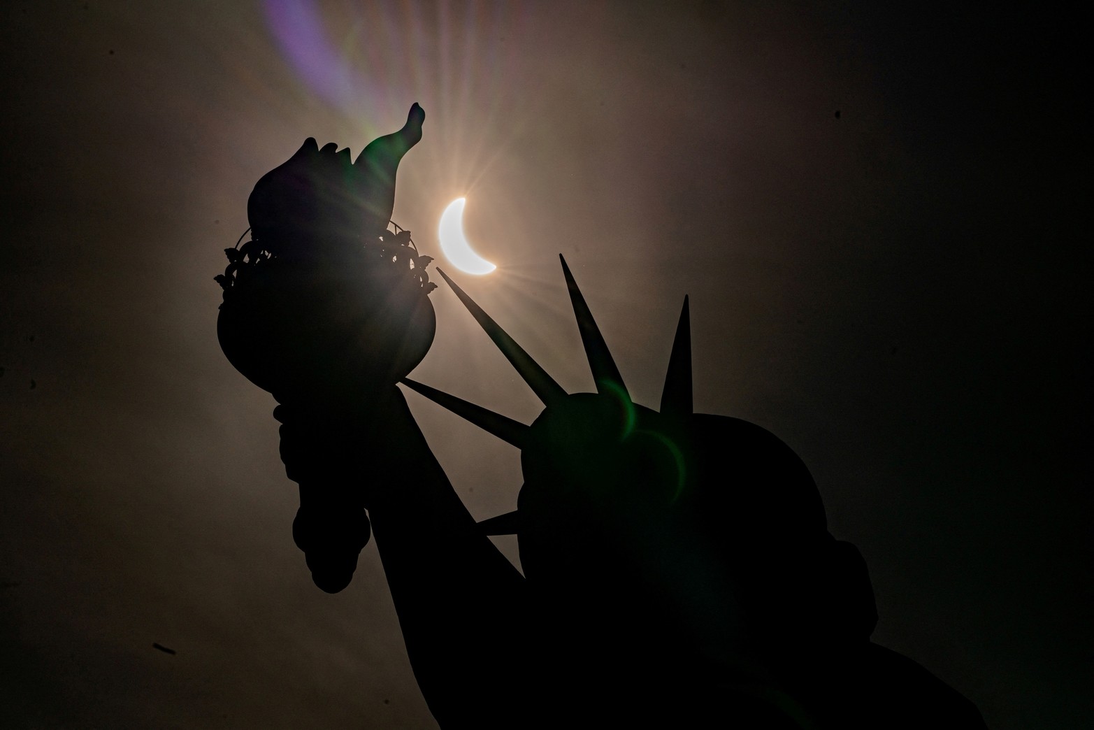 La Estatua de la Libertad se ve durante un eclipse solar parcial, donde la luna bloquea parcialmente el sol, en la Isla de la Libertad en la ciudad de Nueva York.