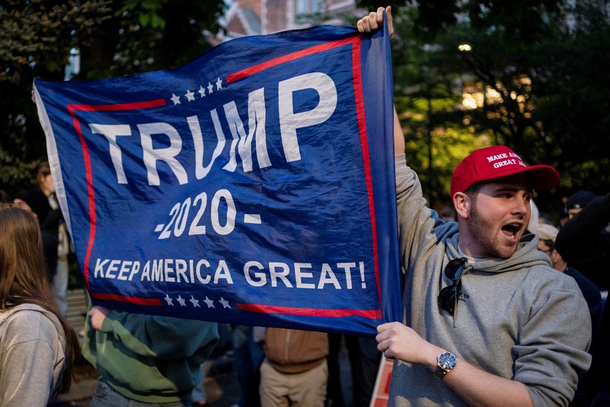 Attendees hold a banner that reads "TRUMP 2020 KEEP AMERICA GREAT!" as they confront encampment protesters after leaving Turning Point USA founder and conservative commentator Charlie Kirk’s speech on campus near a protest encampment of supporters of Palestinians in Gaza, during the ongoing conflict between Israel and the Palestinian Islamist group Hamas, at the University of Washington in Seattle, Washington, U.S. May 7, 2024. REUTERS/David Ryder