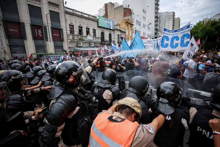 A police officer in riot gear uses a spray during a protest against Argentine President Milei's economic plan, and in demand of resources for soup kitchens and assistance, in Buenos Aires, Argentina March 18, 2024. REUTERS/Agustin Marcarian