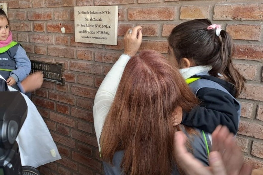 Directivos, invitados y alumnos descubriendo la placa del jardín 354.