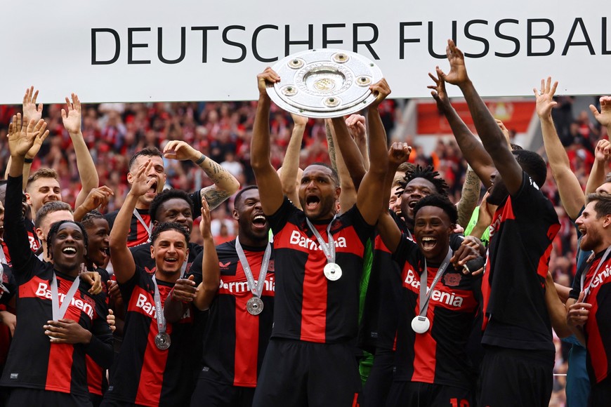 Soccer Football - Bundesliga - Bayer Leverkusen v FC Augsburg - BayArena, Leverkusen, Germany - May 18, 2024
Bayer Leverkusen's Jonathan Tah celebrates with the trophy and teammates after winning the Bundesliga and going unbeaten REUTERS/Wolfgang Rattay DFL REGULATIONS PROHIBIT ANY USE OF PHOTOGRAPHS AS IMAGE SEQUENCES AND/OR QUASI-VIDEO.