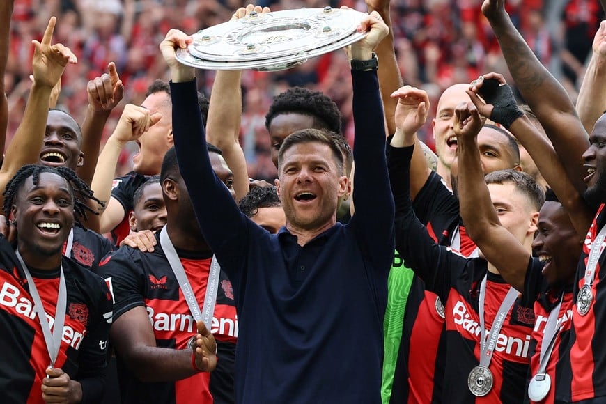 Soccer Football - Bundesliga - Bayer Leverkusen v FC Augsburg - BayArena, Leverkusen, Germany - May 18, 2024
Bayer Leverkusen coach Xabi Alonso celebrates with the trophy after winning the Bundesliga and going unbeaten REUTERS/Wolfgang Rattay DFL REGULATIONS PROHIBIT ANY USE OF PHOTOGRAPHS AS IMAGE SEQUENCES AND/OR QUASI-VIDEO.