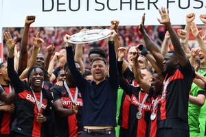 Soccer Football - Bundesliga - Bayer Leverkusen v FC Augsburg - BayArena, Leverkusen, Germany - May 18, 2024
Bayer Leverkusen coach Xabi Alonso celebrates with the trophy and the players after winning the Bundesliga and going unbeaten REUTERS/Wolfgang Rattay DFL REGULATIONS PROHIBIT ANY USE OF PHOTOGRAPHS AS IMAGE SEQUENCES AND/OR QUASI-VIDEO.
