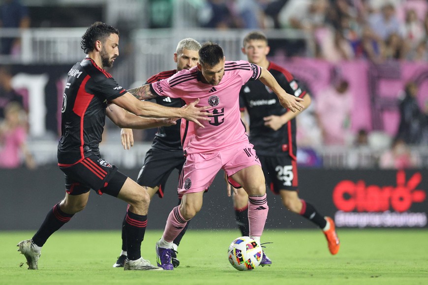 May 18, 2024; Fort Lauderdale, Florida, USA; Inter Miami CF forward Lionel Messi (10) and D.C. United defender Steven Birnbaum (15) battle for the ball in the second half at Chase Stadium. Mandatory Credit: Nathan Ray Seebeck-USA TODAY Sports