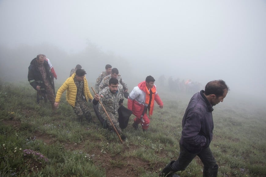 Rescue team carry a body following a crash of a helicopter carrying Iran's President Ebrahim Raisi, in Varzaqan, East Azerbaijan Province, Iran, May 20, 2024.  Stringer/WANA (West Asia News Agency) via REUTERS ATTENTION EDITORS - THIS IMAGE HAS BEEN SUPPLIED BY A THIRD PARTY.?