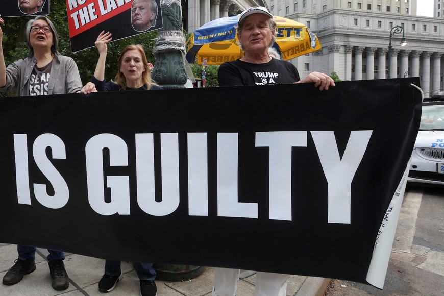 Anti-Trump demonstrators hold placards outside Manhattan criminal court following the verdict in former U.S. President Donald Trump's criminal trial over charges that he falsified business records to conceal money paid to silence porn star Stormy Daniels in 2016, in New York City, U.S. May 30, 2024. REUTERS/Mike Segar