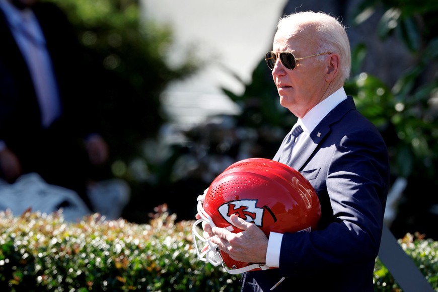 U.S. President Joe Biden carries a helmet gifted to him by the Kansas City Chiefs as he welcomes them to the White House to celebrate their championship season and victory in Super Bowl LVIII, in Washington, U.S., May 31, 2024. REUTERS/Evelyn Hockstein