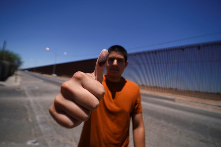 David Enrique Vazquez shows his ink-stained thumb after casting his vote in Mexico's general election next to the border fence between Mexico and the U.S., in Colonia Fronteriza, Mexico June 2, 2024. REUTERS/Victor Medina
