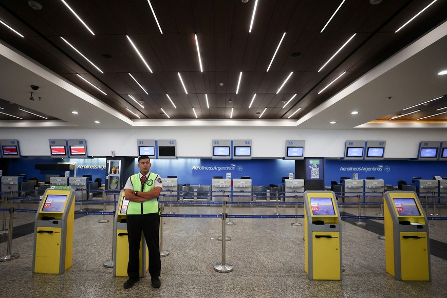 A security worker stands in front of the counters of the Aerolineas Argentinas airline at the Aeroparque Jorge Newbery airport, as the aeronautical union workers go on strike over salary demands, in Buenos Aires, Argentina February 28, 2024. REUTERS/Agustin Marcarian