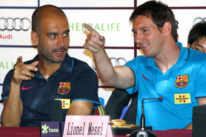 Coach of Barcelona Josep Guardiola (L) talks with his team's player Lionel Messi during a media conference in Beijing August 5, 2010. Barcelona will play Beijing Guoan in a friendly match at the National Stadium, also known as the Bird's Nest, on August 8.     REUTERS/David Gray      (CHINA - Tags: SPORT SOCCER) pekin china Lionel Messi Josep Pep Guardiola gira pretemporada del equipo barcelona futbol conferencia de prensa