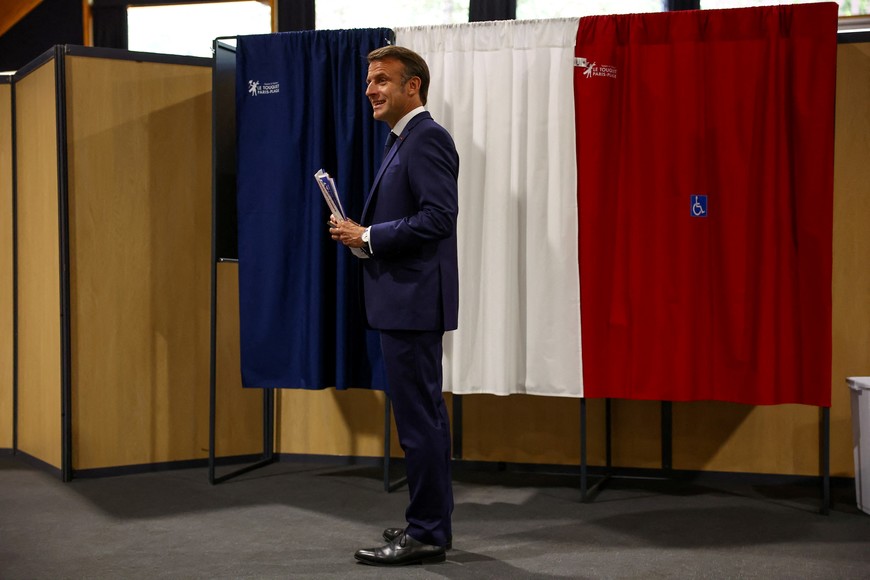 French President Emmanuel Macron stands in front of voting booths during the European Parliament election, at a polling station in Le Touquet-Paris-Plage, France, June 9, 2024. REUTERS/Hannah McKay/Pool