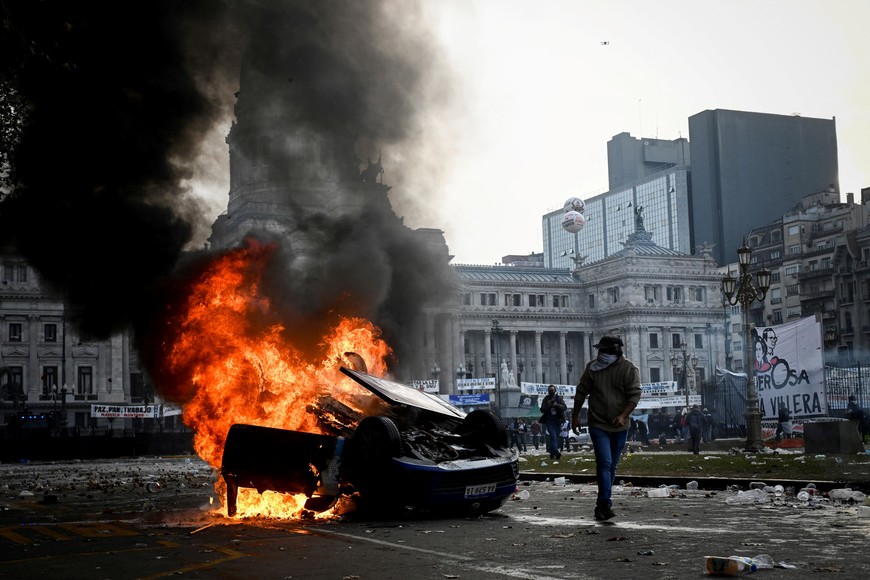 A car burns during a protest near the National Congress, on the day Senators debate Argentina's President Javier Milei's economic reform bill, known as the "omnibus bill", in Buenos Aires, Argentina, June 12, 2024. REUTERS/Mariana Nedelcu