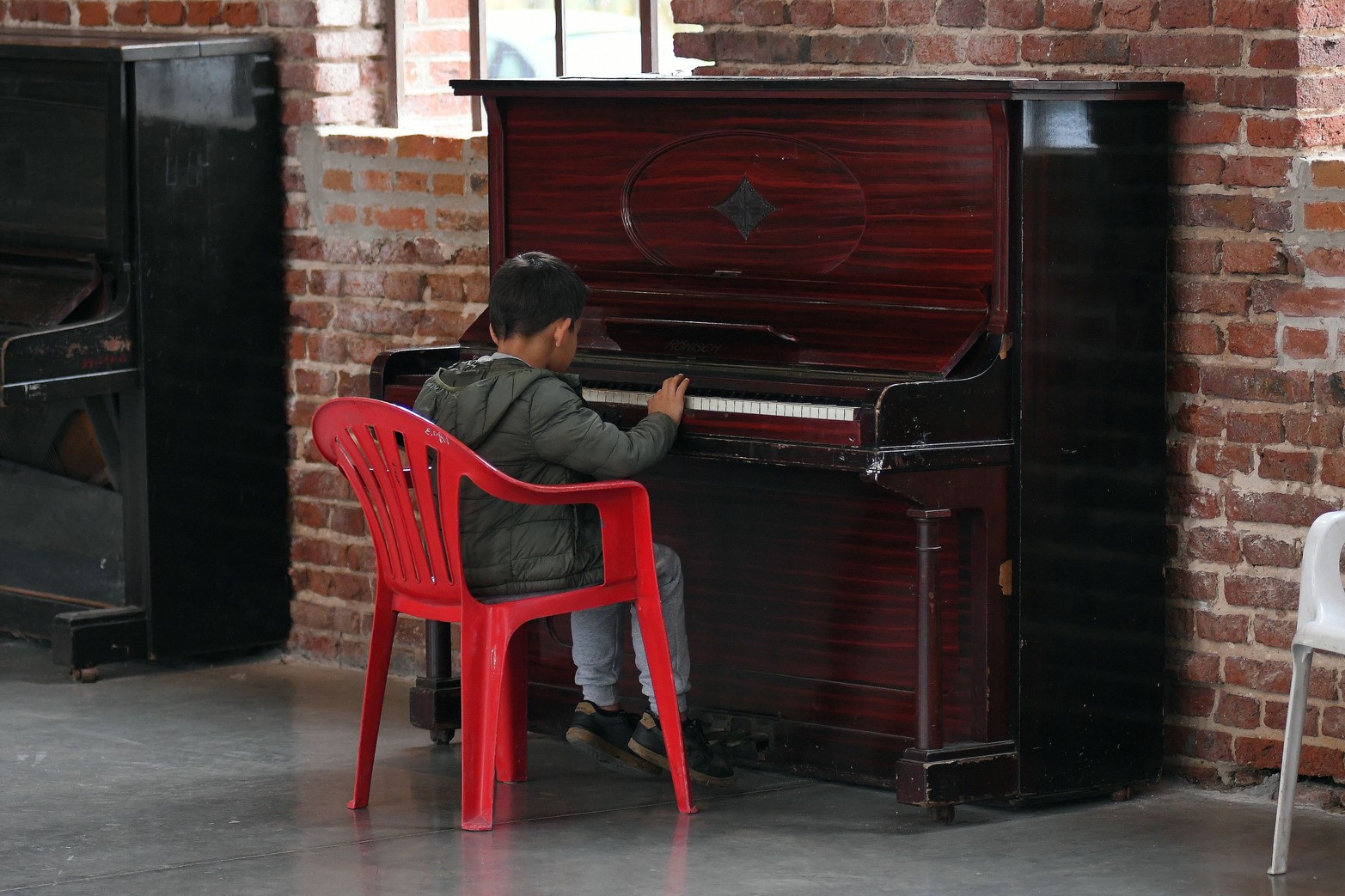 Un niño, para pasar el tiempo, se acercó a un piano en las instalaciones del ex Molino Marconetti. Allí funciona el Liceo Municipal Antonio Fuentes del Arco.