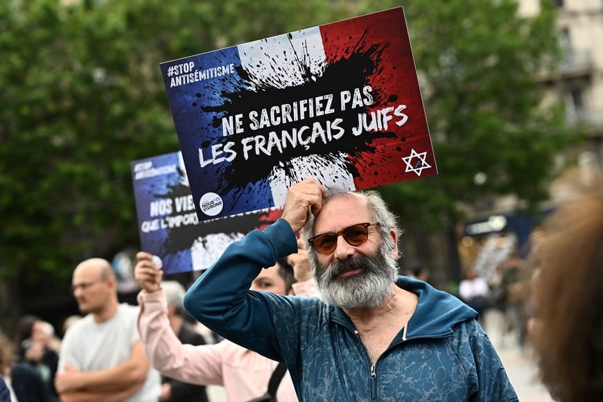 People attend a demonstration against anti-Semitism in front of Paris City Hall after three teenagers aged 12 to 13 indicted in Courbevoie, accused of rape and anti-Semitic violence against a 12-year-old girl, in Paris, France, June 19, 2024. The slogan reads "Do not sacrifice the French Jews".  REUTERS/Dylan Martinez
