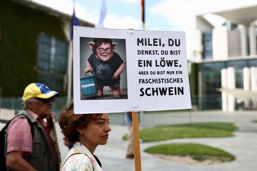 A placard shows a photo depicting Argentine President Javier Milei as protesters gather near the Chancellery on the day German Chancellor Olaf Scholz receives Argentine President Javier Milei, in Berlin, Germany, June 23, 2024. REUTERS/Liesa Johannssen