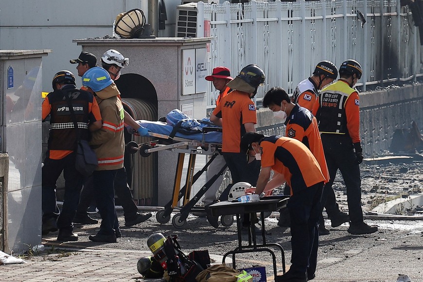 Emergency personnel carry the body of a person killed in a deadly fire at a lithium battery factory owned by South Korean battery maker Aricell, in Hwaseong, South Korea, June 24, 2024. REUTERS/Kim Hong-ji