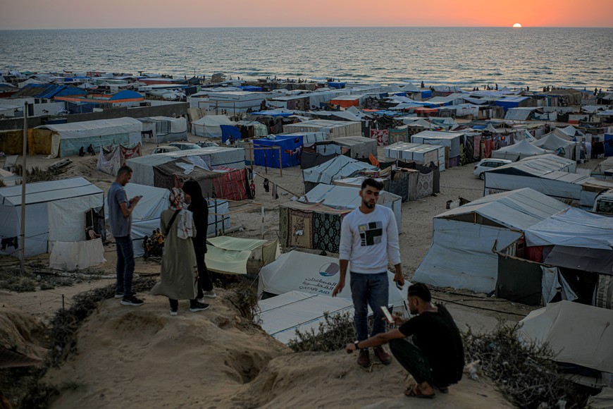 (240604) -- GAZA, 4 junio, 2024 (Xinhua) -- Personas permanecen sobre las tiendas de campaña provisionales para palestinos desplazados en el área de Mawasi, en la ciudad de Khan Younis, en el sur de la Franja de Gaza, el 4 de junio de 2024. El Ejército israelí amplió el 7 de mayo sus operaciones en Rafah y ordenó a más de 1,5 millones de palestinos desplazarse hacia Khan Younis y otras zonas del centro de Gaza. La Agencia de Naciones Unidas para los Refugiados de Palestina en Oriente Próximo (UNRWA, siglas en inglés) calcula que estas zonas albergan actualmente a cerca de 1,7 millones de personas. (Xinhua/Rizek Abdeljawad) (oa) (ah)