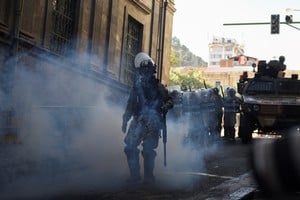 A member of the military police walks amid tear gas as Bolivia's President Luis Arce "denounced the irregular mobilization" of some units of the country's army, in La Paz, Bolivia June 26, 2024. REUTERS/Claudia Morales