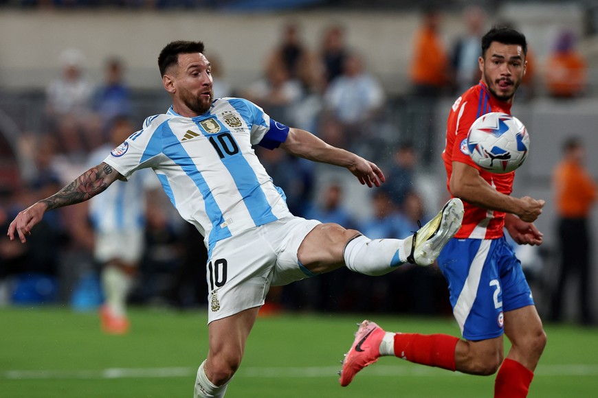 Soccer Football - Copa America 2024 - Group B - Chile v Argentina - MetLife Stadium, East Rutherford, New Jersey, United States - June 25, 2024 
Argentina's Lionel Messi in action with Chile's Gabriel Suazo REUTERS/Agustin Marcarian