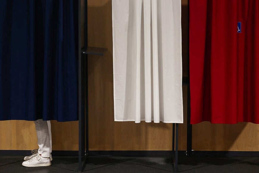 A voter stands in a voting booth, during the first round of the early French parliamentary elections at a polling station in Le Touquet-Paris-Plage, France, June 30, 2024. REUTERS/Yara Nardi