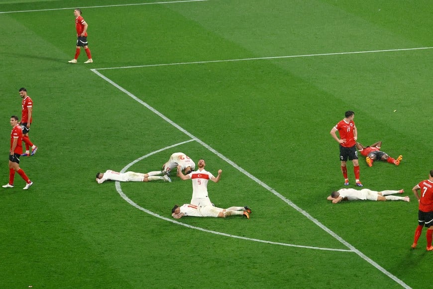 Soccer Football - Euro 2024 - Round of 16 - Austria v Turkey - Leipzig Stadium, Leipzig, Germany - July 2, 2024
Turkey's Salih Ozcan celebrates after the match as teammates collapse on the pitch and Austria players look dejected REUTERS/Lisi Niesner     TPX IMAGES OF THE DAY