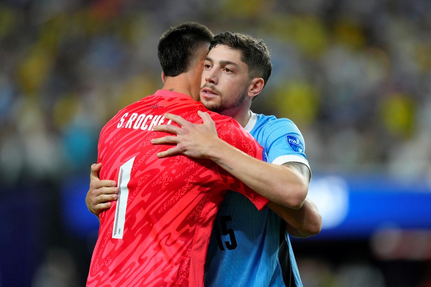 Jul 6, 2024; Las Vegas, NV, USA; Uruguay midfielder Federico Valverde (15) hugs goalkeeper Sergio Rochet (1) after scoring a goal during a penalty shootout against Brazil at Allegiant Stadium. Mandatory Credit: Lucas Peltier-USA TODAY Sports