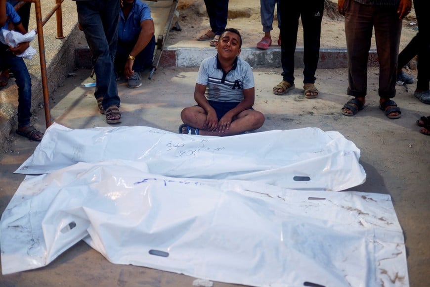 A boy reacts next to the bodies of Palestinians, following an Israeli strike, amid the Israel-Hamas conflict, at Nasser hospital in Khan Younis, in the southern Gaza Strip, July 9, 2024. REUTERS/Mohammed Salem