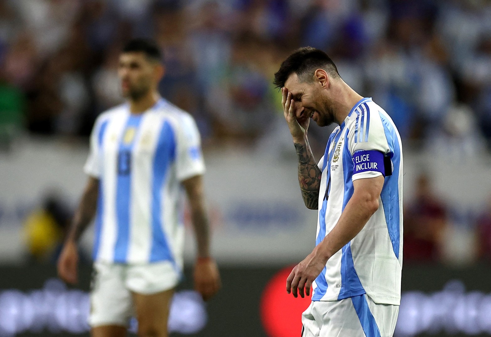 Messi se toma el rostro. El defensor "Cuti" atrás parece estar también atento al mas grande del grupo. 