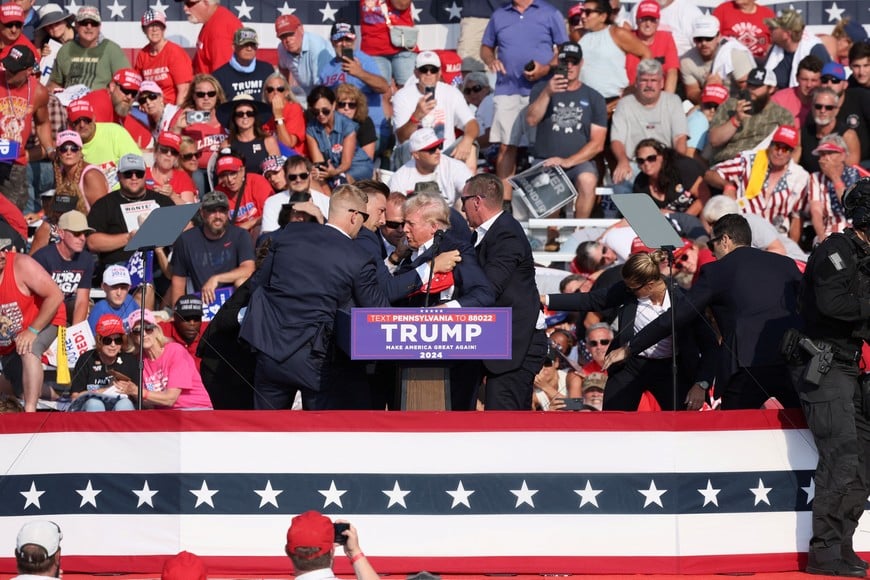 Republican presidential candidate and former U.S. President Donald Trump is assisted by guards during a campaign rally at the Butler Farm Show in Butler, Pennsylvania, U.S., July 13, 2024. REUTERS/Brendan McDermid