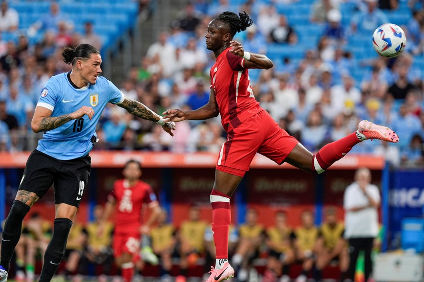 Jul 13, 2024; Charlotte, NC, USA; Canada midfielder Ismael Kone (8) reverse kicks the ball towards the goal defended by Uruguay forward Darwin Nunez (19) during the first half at Bank of America Stadium. Mandatory Credit: Jim Dedmon-USA TODAY Sports