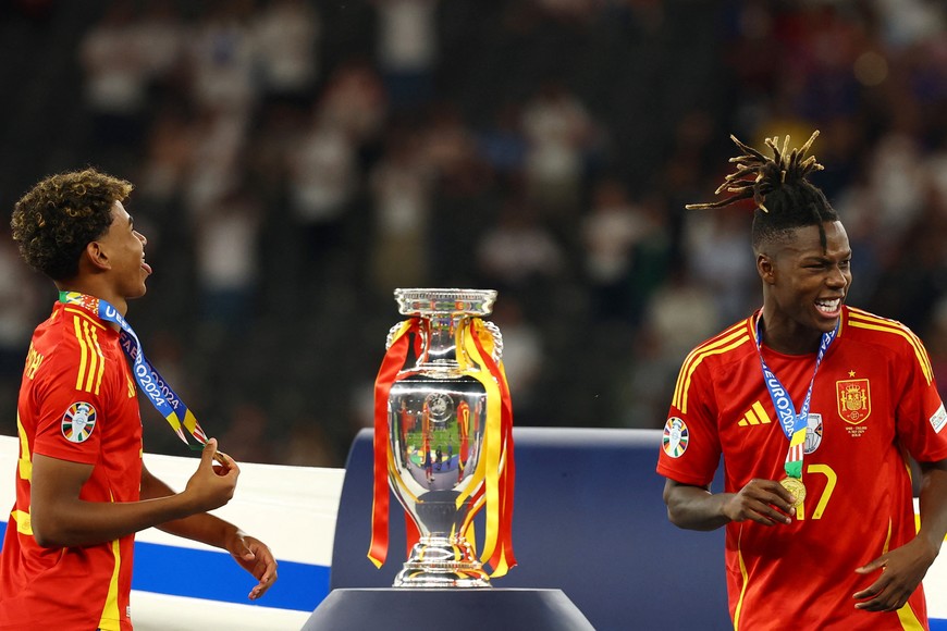 Soccer Football - Euro 2024 - Final - Spain v England - Berlin Olympiastadion, Berlin, Germany - July 14, 2024
Spain's Lamine Yamal and Nico Williams walk past the trophy after collecting their winners medals REUTERS/Kai Pfaffenbach