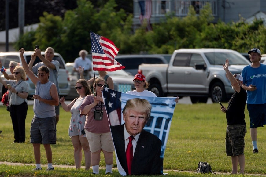 Supporters react as Trump Force One, carrying Republican presidential candidate and former U.S. President Donald Trump, lands in Milwaukee, Wisconsin, U.S., July 14, 2024 a day after he survived an assassination attempt at a rally in Butler, Pennsylvania.  REUTERS/Cheney Orr