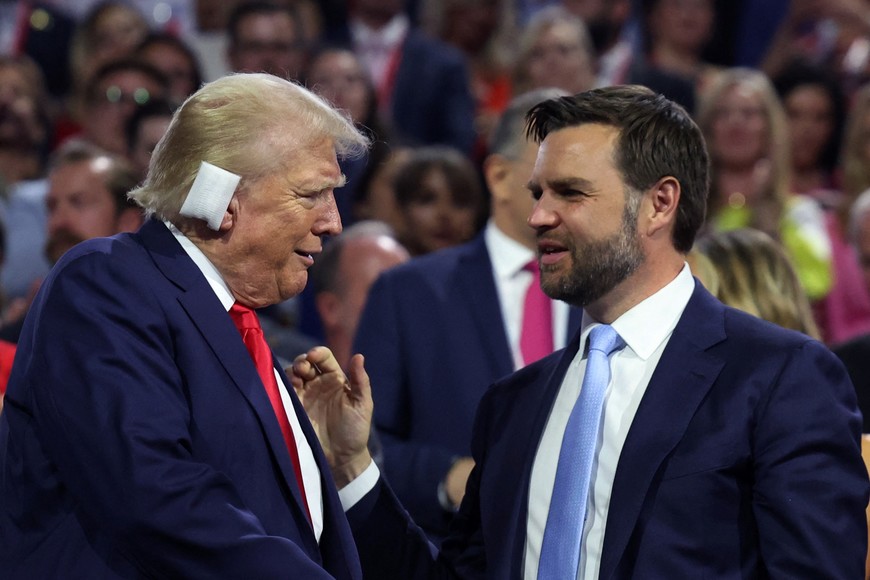 Republican presidential nominee and former U.S. President Donald Trump and Republican vice presidential nominee J.D. Vance interact during Day 1 of the Republican National Convention (RNC), at the Fiserv Forum in Milwaukee, Wisconsin, U.S., July 15, 2024. REUTERS/Andrew Kelly