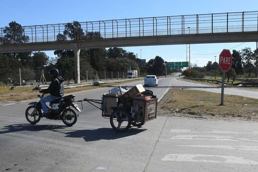 Motocicletas y bicicletas con carritos, cruzan a diario de un barrio a otro. Foto: Guillermo Di Salvatore