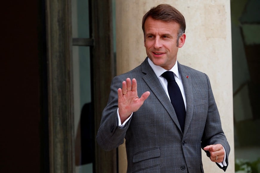 French President Emmanuel Macron waves to journalists as he waits for the arrival of a guest at the Elysee Palace in Paris, France, July 16, 2024. REUTERS/Gonzalo Fuentes