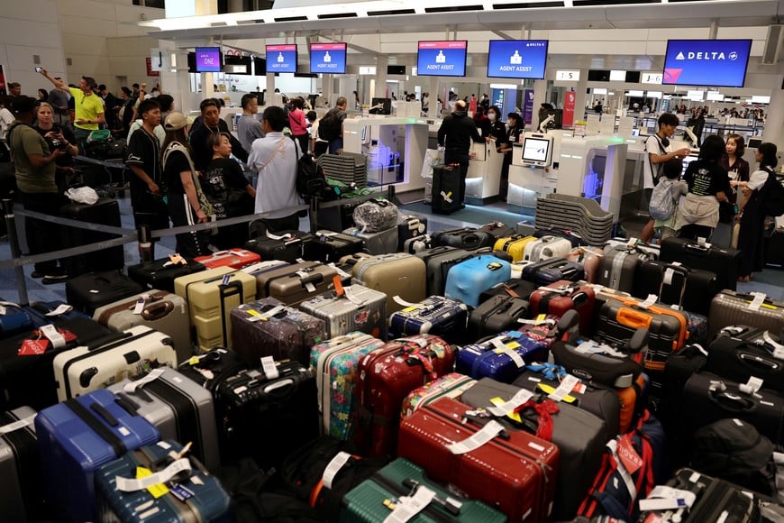 Passengers stands in a line at Delta Airlines’ counter following a global IT outage, at Haneda International Airport in Tokyo, Japan July 19,  2024. REUTERS/Kim Kyung-Hoon