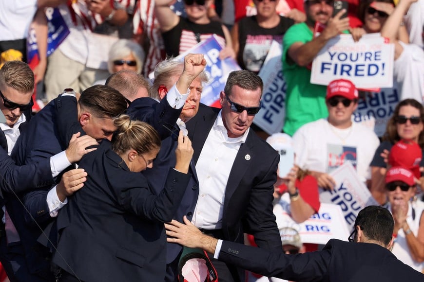 FILE PHOTO: Republican presidential candidate and former U.S. President Donald Trump gestures with a bloodied ear as multiple shots rang out during a campaign rally at the Butler Farm Show in Butler, Pennsylvania, U.S., July 13, 2024. REUTERS/Brendan McDermid/File Photo