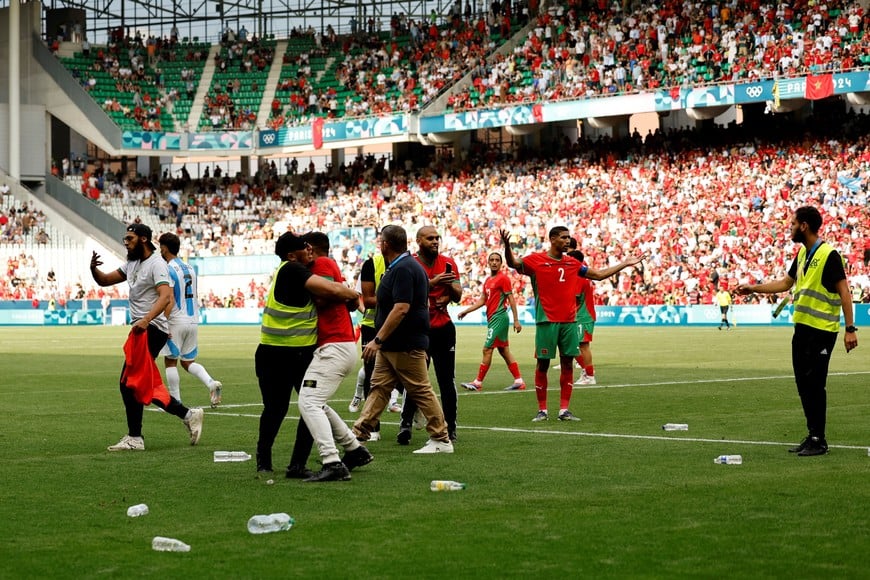 Paris 2024 Olympics - Football - Men's Group B - Argentina vs Morocco - Geoffroy-Guichard Stadium, Saint-Etienne, France - July 24, 2024.
Achraf Hakimi of Morocco reacts as pitch invaders run to the pitch after the match. REUTERS/Thaier Al-Sudani