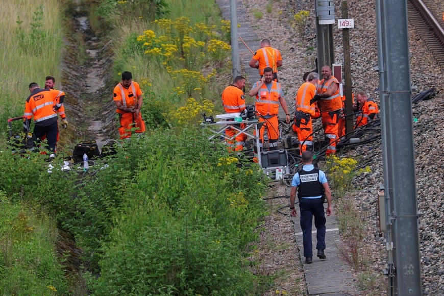 SNCF railway workers and police officers work at the site where vandals targeted France's high-speed train network with a series of coordinated actions that brought major disruption, ahead of the Paris 2024 Olympics opening ceremony, in Croisilles, northern France  July 26, 2024. REUTERS/Brian Snyder