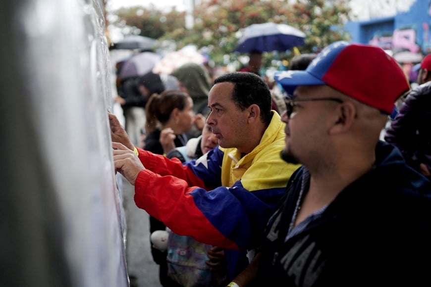 Venezuelans check their voting stations during their country's presidential election, at a polling station at the Colegio Tecnico Palermo, in Bogota, Colombia, July 28, 2024. REUTERS/Nathalia Angarita