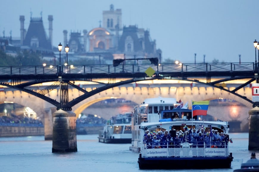 (240726) -- PARIS, 26 julio, 2024 (Xinhua) -- La delegación de Venezuela es vista pasando bajo un puente a bordo de un bote en el desfile flotante en el río Sena durante la ceremonia de inauguración de los Juegos Olímpicos de París 2024, en París, Francia, el 26 de julio de 2024. (Xinhua/Clodagh Kilcoyne/REUTERS/Pool) (oa) (ce)