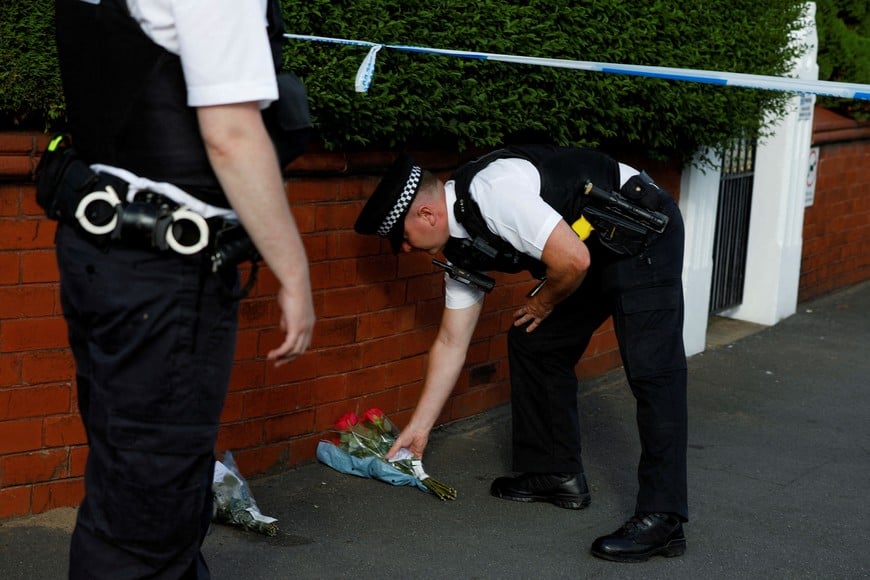 A police officer places flowers, given by residents, behind the police cordon near the scene of a stabbing incident in Southport, Britain, July 29, 2024. REUTERS/Temilade Adelaja     TPX IMAGES OF THE DAY