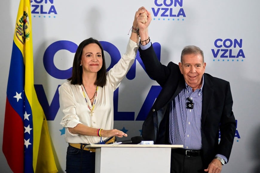 Venezuelan opposition leader Maria Corina Machado and opposition presidential candidate Edmundo Gonzalez raise their hands during a press conference following the announcement by the National Electoral Council that Venezuela's President Nicolas Maduro won the presidential election, in Caracas, Venezuela, July 29, 2024. REUTERS/Maxwell Briceno